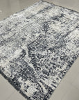 Luxurious Xena Gray Hand Knotted Wool Rug, showcasing a subtly textured, sophisticated gray palette with hand-knotted construction, seen in a room setting that highlights its understated elegance.