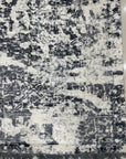 Luxurious Xena Gray Hand Knotted Wool Rug, soft gray tones and subtle geometric patterns ground a modern living space, seen with a minimalist side table and neutral-toned decor.