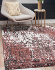 Ava Dahlia Red Hand Knotted Wool Rug, showcasing a vibrant floral pattern in warm red tones, lies gracefully on a light hardwood floor, its intricate hand-knotted construction evident in the texture and detail.