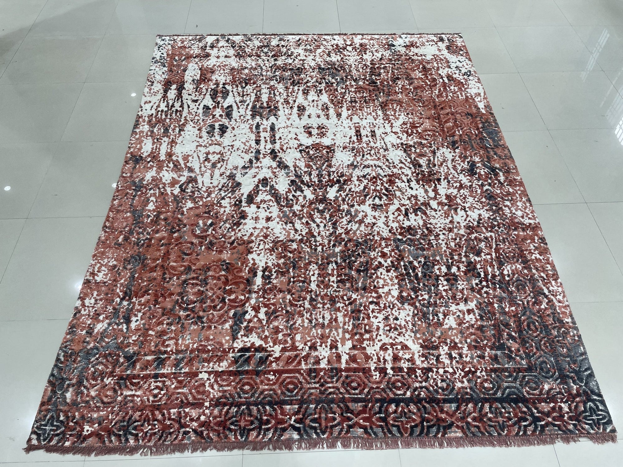 Ava Dahlia Red Hand Knotted Wool Rug displayed in a bright, naturally lit living space; the vibrant red wool rug with intricate floral designs anchors the room, contrasting beautifully with the neutral furniture and hardwood floors.