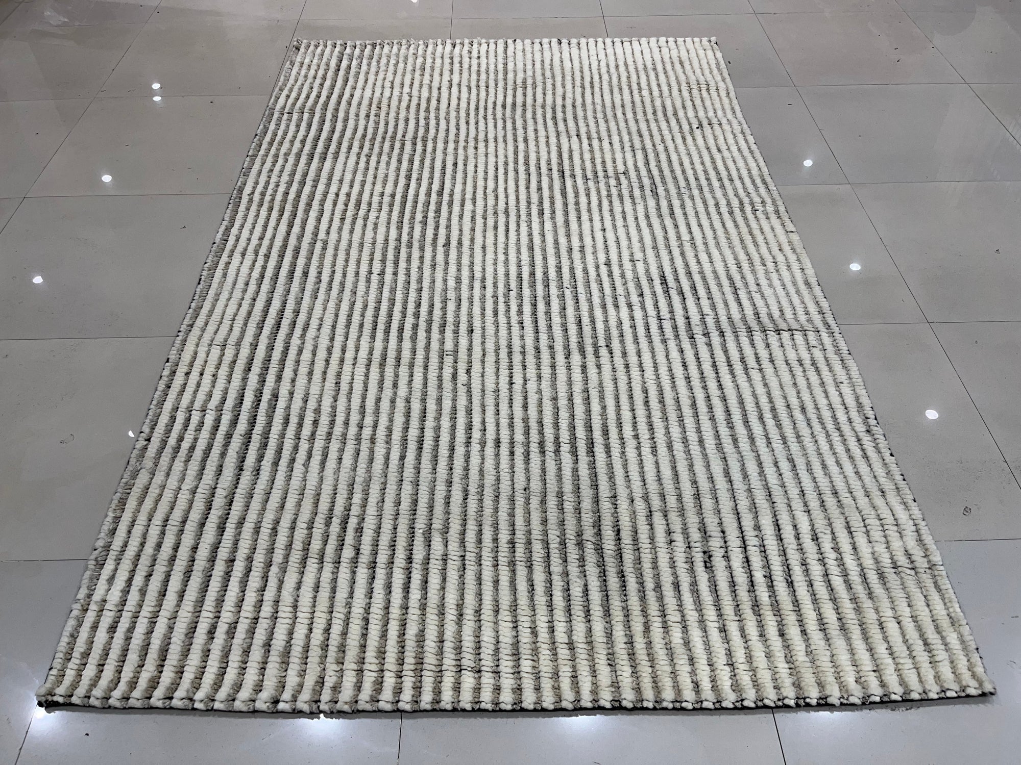Graceful Vibrant Ivory Hand Knotted Wool Rug, a luxurious ivory wool rug with intricate hand-knotted detailing, adds warmth and texture to a room setting.