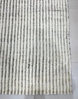 Graceful Vibrant Ivory Hand Knotted Wool Rug displayed in a warmly lit room, showcasing intricate design details of the hand-knotted construction and soft ivory hue.