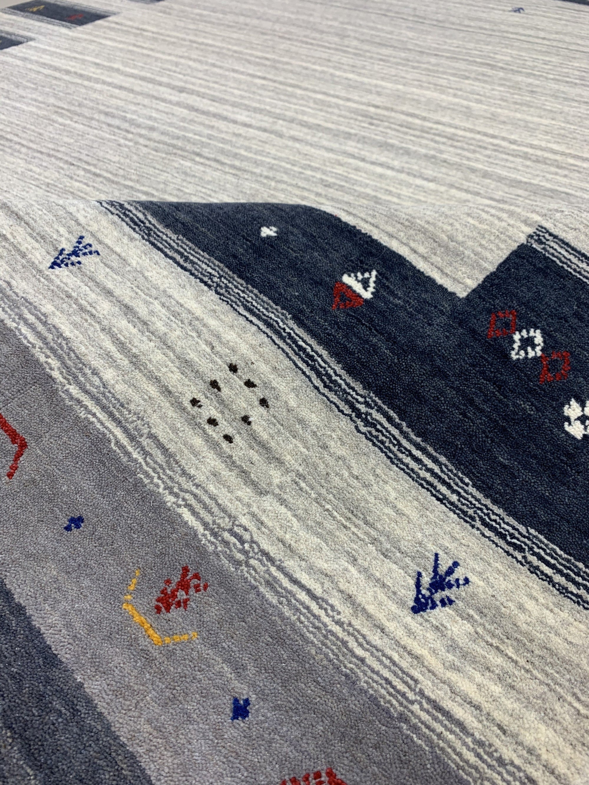 Radiant Gabbeh Multicolor Handmade Wool Rug, bursting with vibrant hues and geometric designs, laying flat to display its colorful wool construction and handcrafted details.