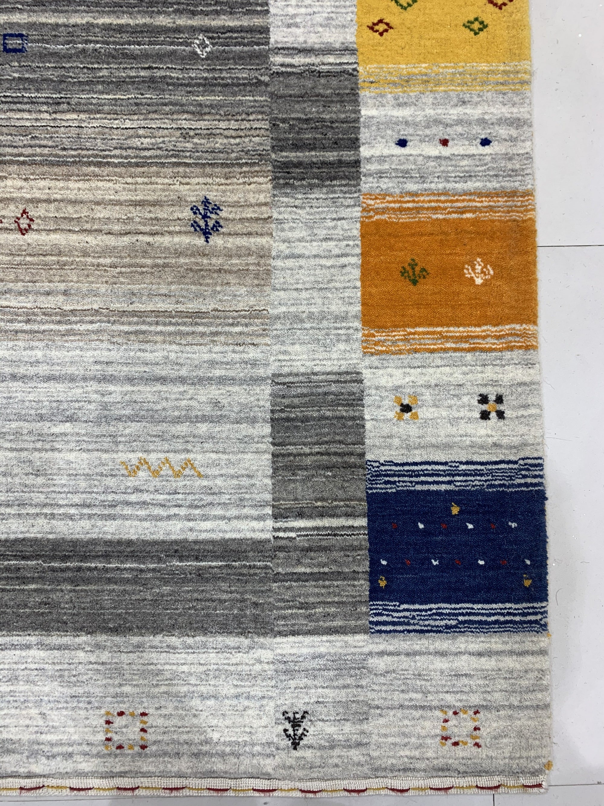 Classic Gabbeh Multicolor Hand Knotted Wool Rug, displaying vibrant bands of earthy tones, from deep reds and browns to warm yellows and greens, intricately hand-knotted with characteristic Gabbeh simplicity and texture.