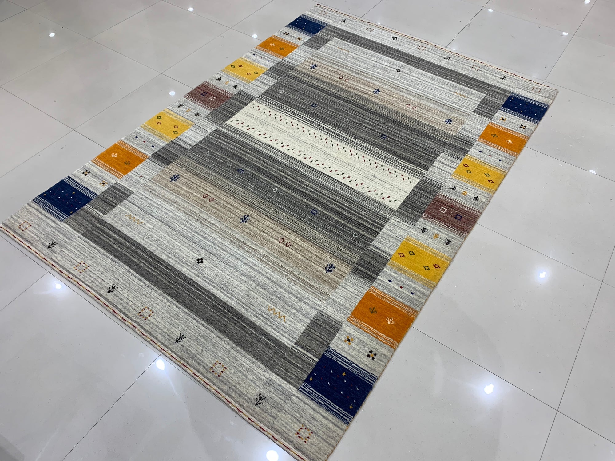 Classic Gabbeh Multicolor Hand Knotted Wool Rug displayed on a light wood floor; vibrant stripes of red, blue, yellow, and green create a playful, modern aesthetic.