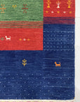 Beautiful Gabbeh Navy Handmade Wool Rug, displaying a textured weave and minimalist geometric design in deep navy blue, lies on a light-colored hardwood floor showcasing its rich color and artisanal construction.