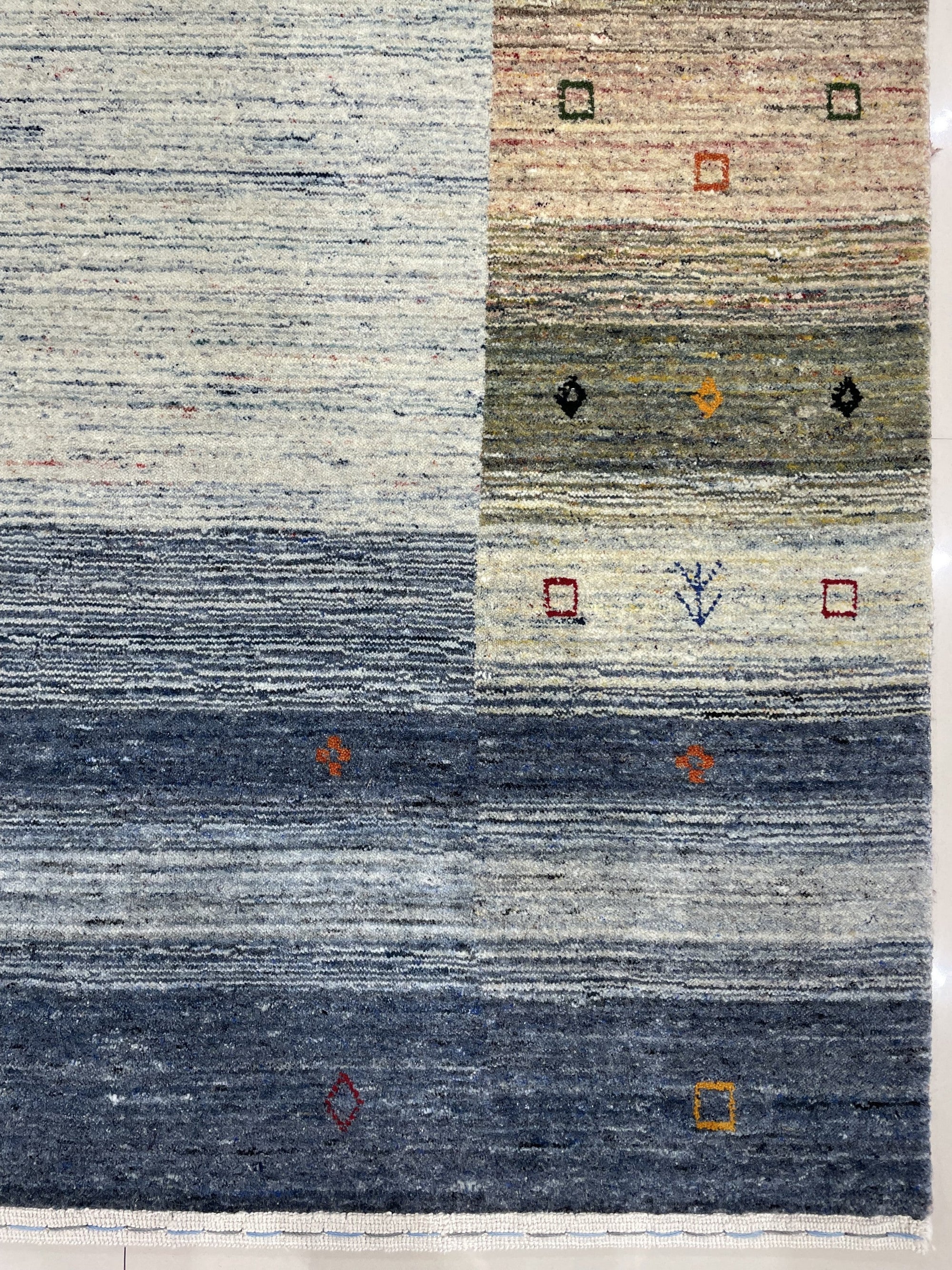 Chic Gabbeh Gray Handmade Wool Rug, its textured gray wool construction adding warmth and subtle pattern to a brightly lit interior.