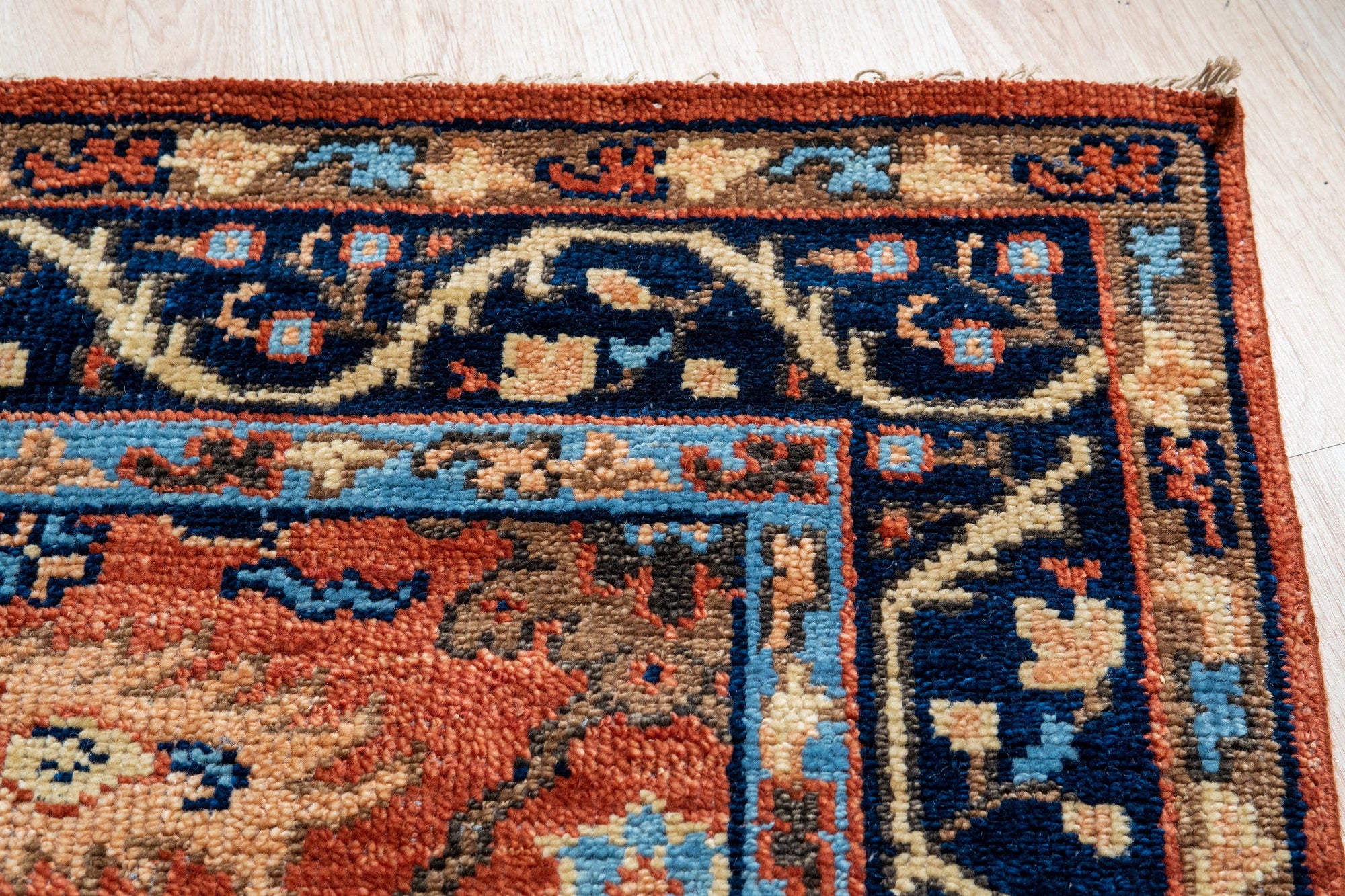 Elegant Traditional Rust Hand Knotted Wool Rug, a warm rust-toned wool rug with intricate traditional patterns, showcased in a brightly lit interior setting.