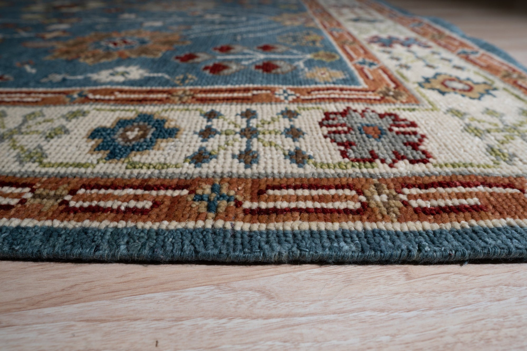 Mira Traditional Red Hand Knotted Wool Rug, richly patterned and vibrant, displayed in a modern living room setting.