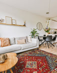 Mira Traditional Red Hand Knotted Wool Rug, vibrant reds and intricate patterns flow across this hand-knotted wool rug, showcased as a warm accent in a comfortably furnished living room.