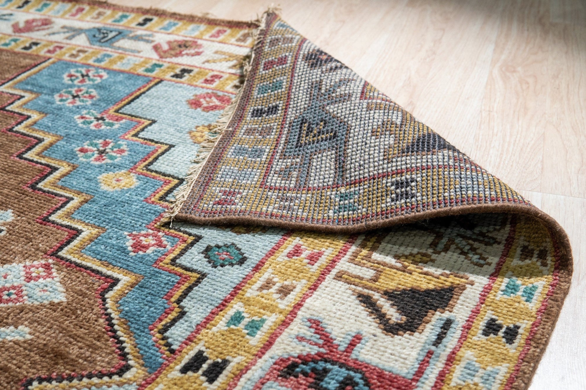 Classic Dazzling Brown Hand Knotted Wool Rug, displaying intricate patterns in warm browns and creams, hand-knotted wool construction evident in its dense pile, seen in a styled home setting.