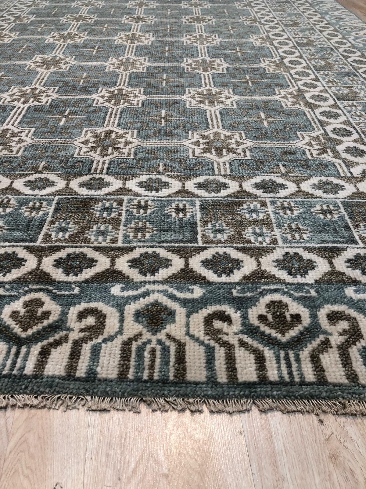 Charming Alluring Gray Hand Knotted Wool Rug, a soft gray wool rug featuring a subtle, textured pattern, laying on a light wood floor, bringing warmth and sophisticated simplicity to the space.