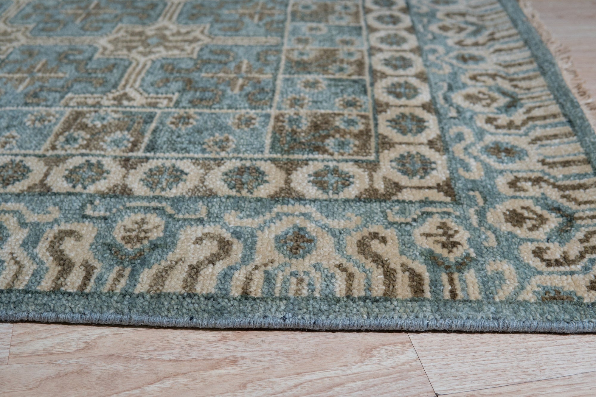 Charming Alluring Gray Hand Knotted Wool Rug displaying a subtle geometric pattern, its soft gray tones creating a sophisticated and calming atmosphere in a well-lit living room setting.