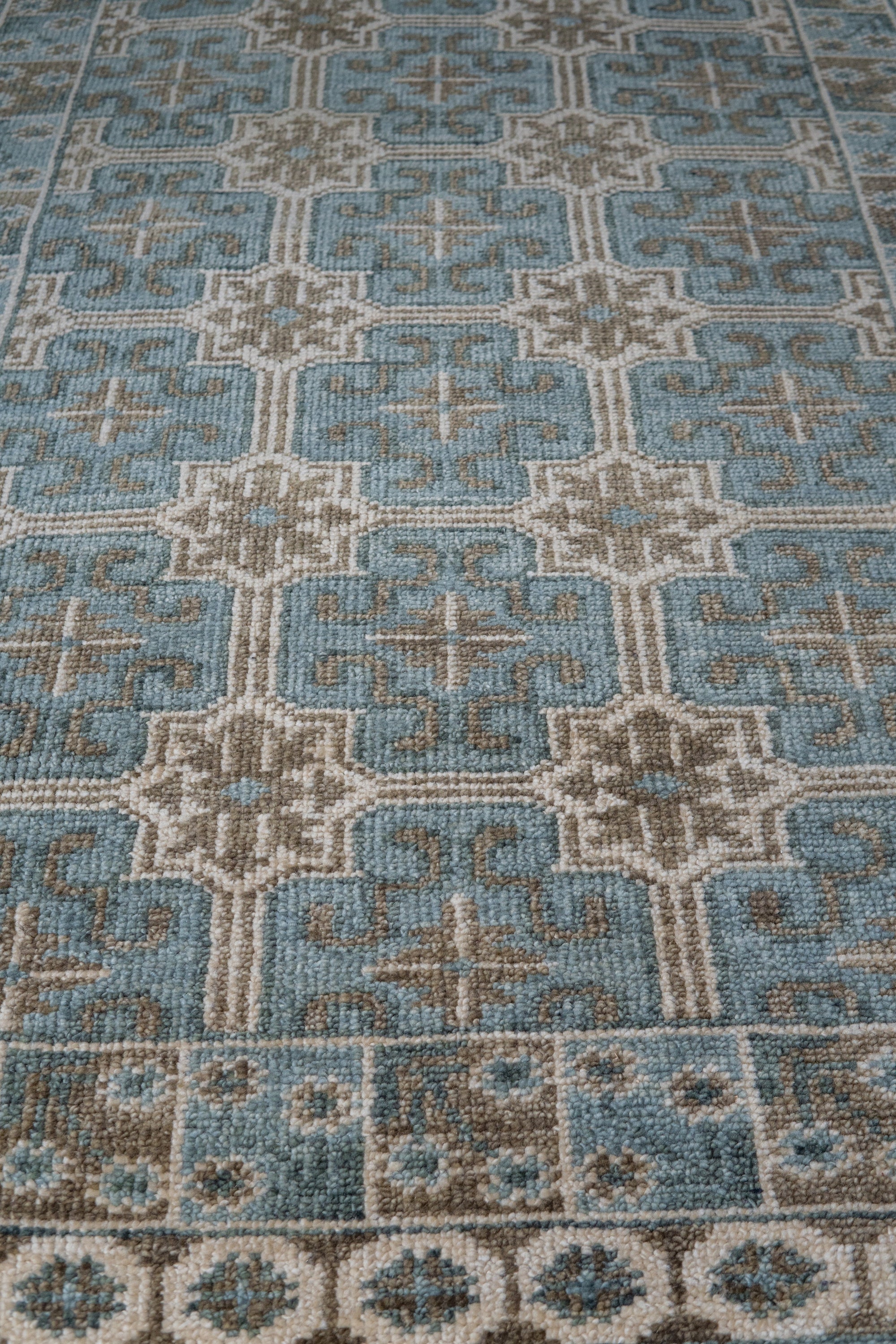 Charming Alluring Gray Hand Knotted Wool Rug displayed on a light hardwood floor, its soft gray hues and hand-knotted texture creating a subtly textured and inviting space.