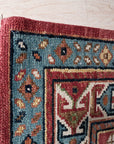 Kira Traditional Red Hand Knotted Wool Rug, vibrant reds and intricate traditional patterns adorn this hand-knotted wool rug, seen in a styled room setting.