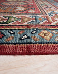 Kira Traditional Red Hand Knotted Wool Rug displayed. Red and ivory tones define this hand-knotted wool rug, showcasing intricate traditional patterns.