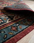 Kira Traditional Red Hand Knotted Wool Rug, vibrant reds and intricate patterns unfold across this hand-knotted wool rug, its classic design adding warmth to a softly lit room.