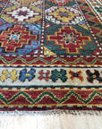 Lydia Kazak Brown Hand Knotted Wool Rug, its intricate geometric patterns in warm browns and creams highlighted in a natural light setting.