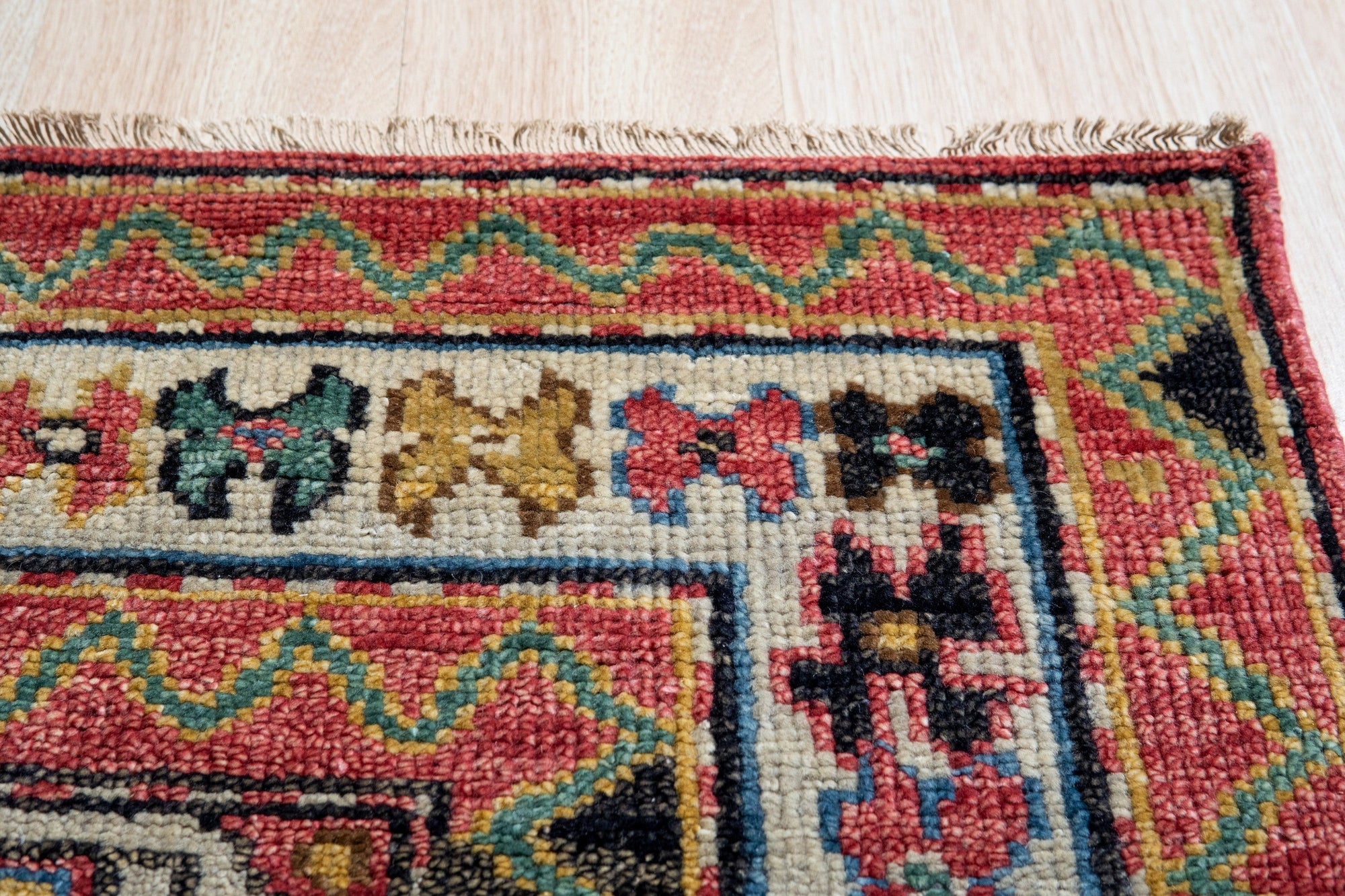 Lydia Kazak Brown Hand Knotted Wool Rug, showcasing a warm palette of browns and creams intricately woven in a traditional Kazak pattern, bringing texture and earthy elegance to a softly lit room.