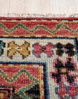 Lydia Kazak Brown Hand Knotted Wool Rug, showcasing a warm palette of browns and creams intricately woven in a traditional Kazak pattern, bringing texture and earthy elegance to a softly lit room.