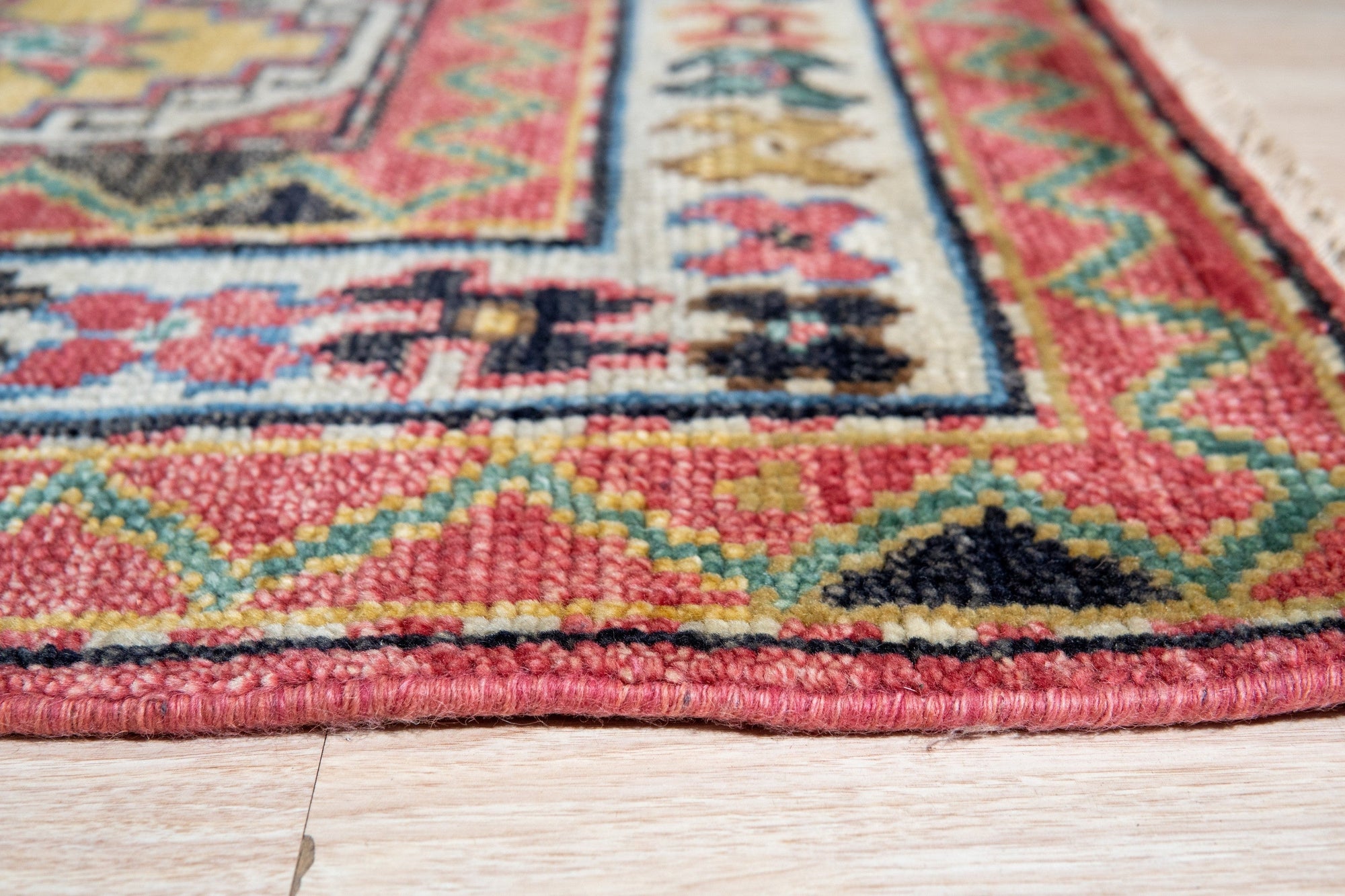 Lydia Kazak Brown Hand Knotted Wool Rug, showcasing its intricate geometric design and warm brown hues. The hand-knotted construction is evident in the luxurious texture.