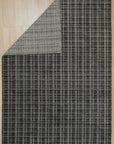 Sumptuous Jade Charcoal Handmade Wool & Viscose Rug, its deep charcoal background softly merging into jade green highlights, the plush wool and shimmering viscose fibers creating a luxurious texture underfoot, showcased in a warmly lit living room.