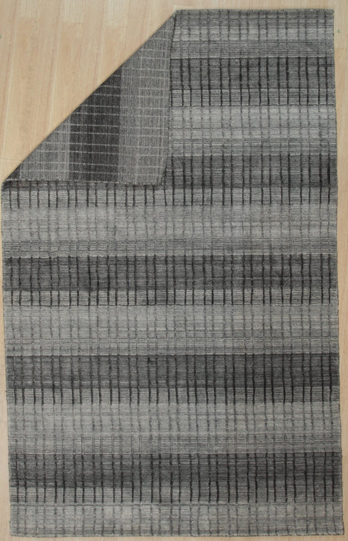 Comfortable Modern Gray Hand Knotted Wool & Viscose Rug, a cool grey and subtly textured rug, anchors a minimalist living room with its hand-knotted elegance.