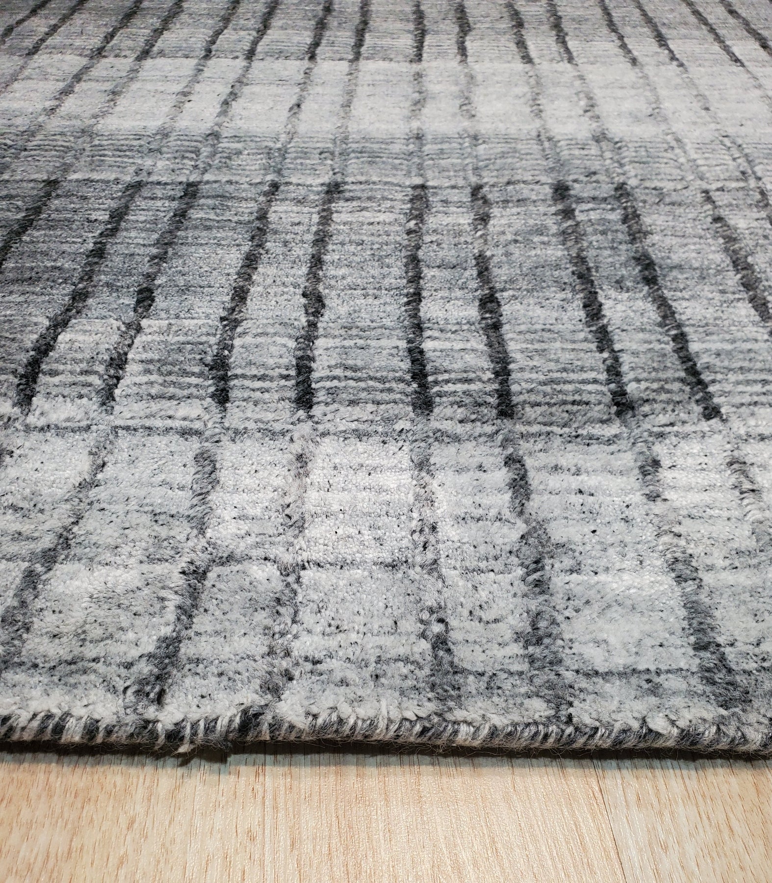 Comfortable Modern Gray Hand Knotted Wool & Viscose Rug, a textured expanse of muted gray, its hand-knotted construction suggesting plush comfort in a contemporary living space.