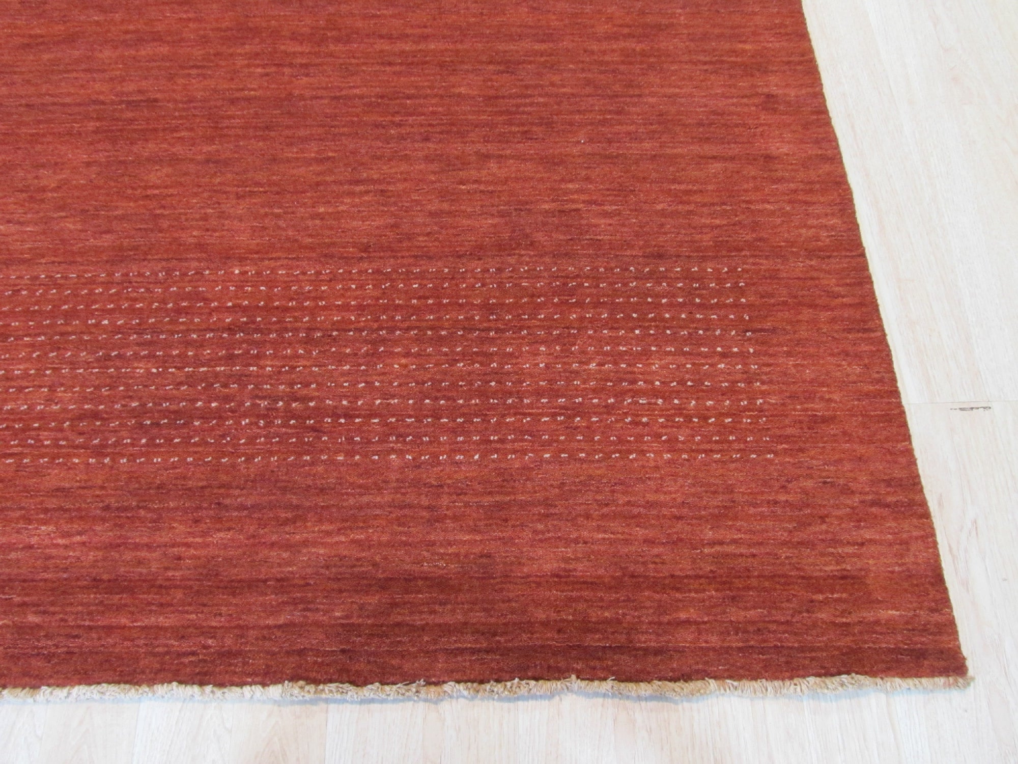 Willow Dazzling Red Handmade Wool Rug, vibrant red wool floor covering with intricate geometric patterns, displayed within a modern living room setting.