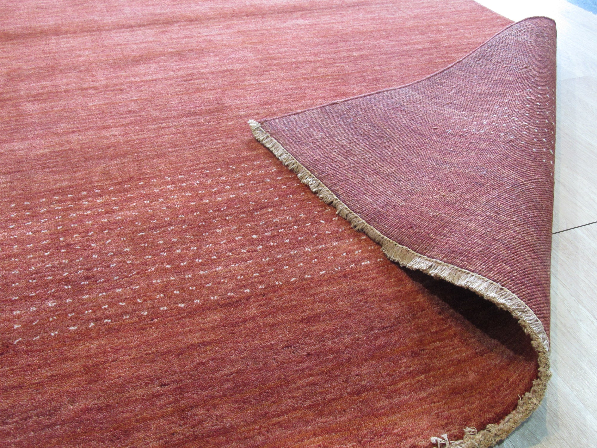 Willow Dazzling Red Handmade Wool Rug, a vibrant field of scarlet wool, hand-knotted with intricate, geometric patterns, lending warmth and bold texture to a contemporary living space.