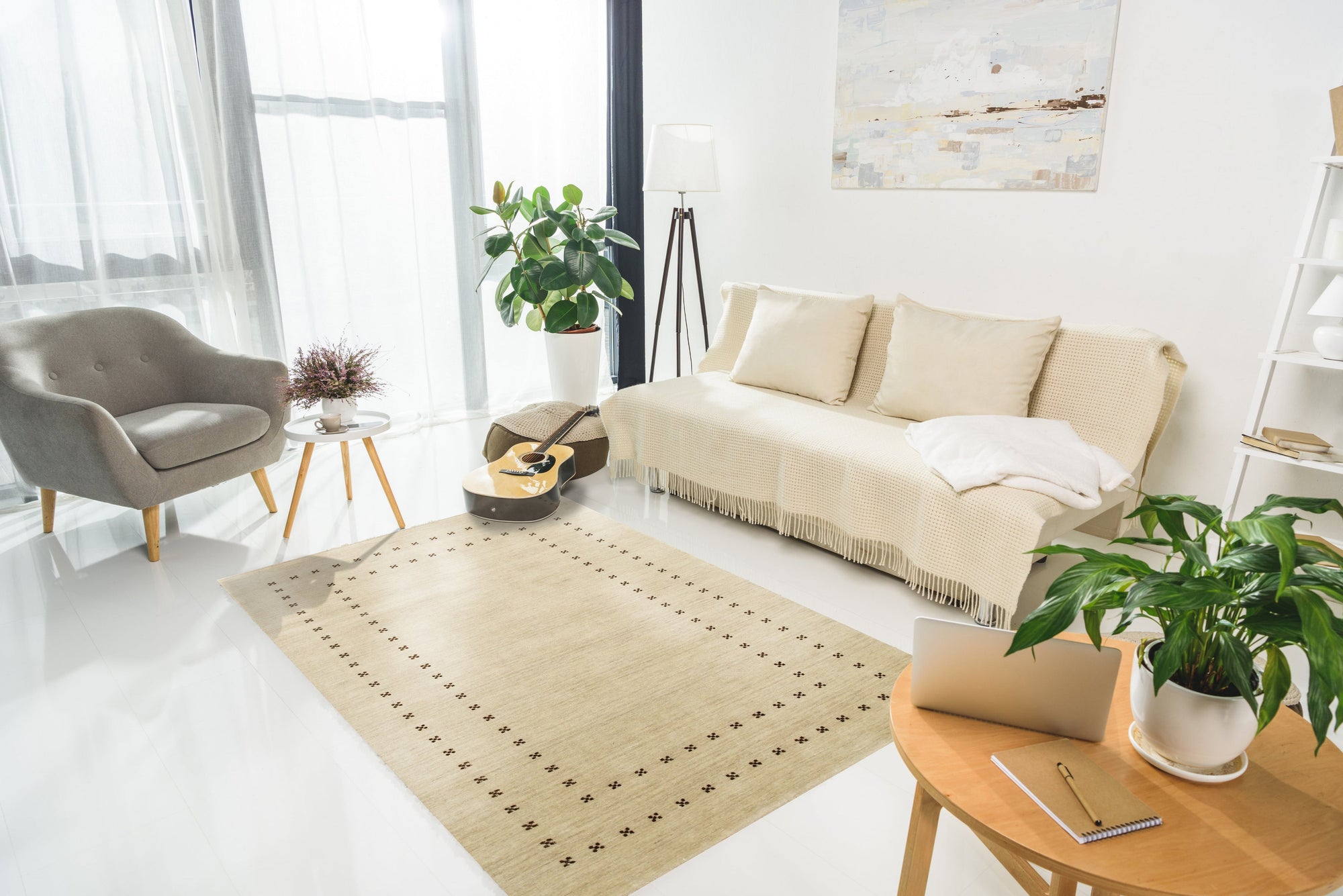 Jasmine Alluring Beige Handmade Wool Rug graces a warmly lit living room. Soft, alluring beige wool forms a captivating pattern, suggesting elegance underfoot. Sunlight highlights the rug’s intricate handmade construction, anchoring a cozy and inviting space.