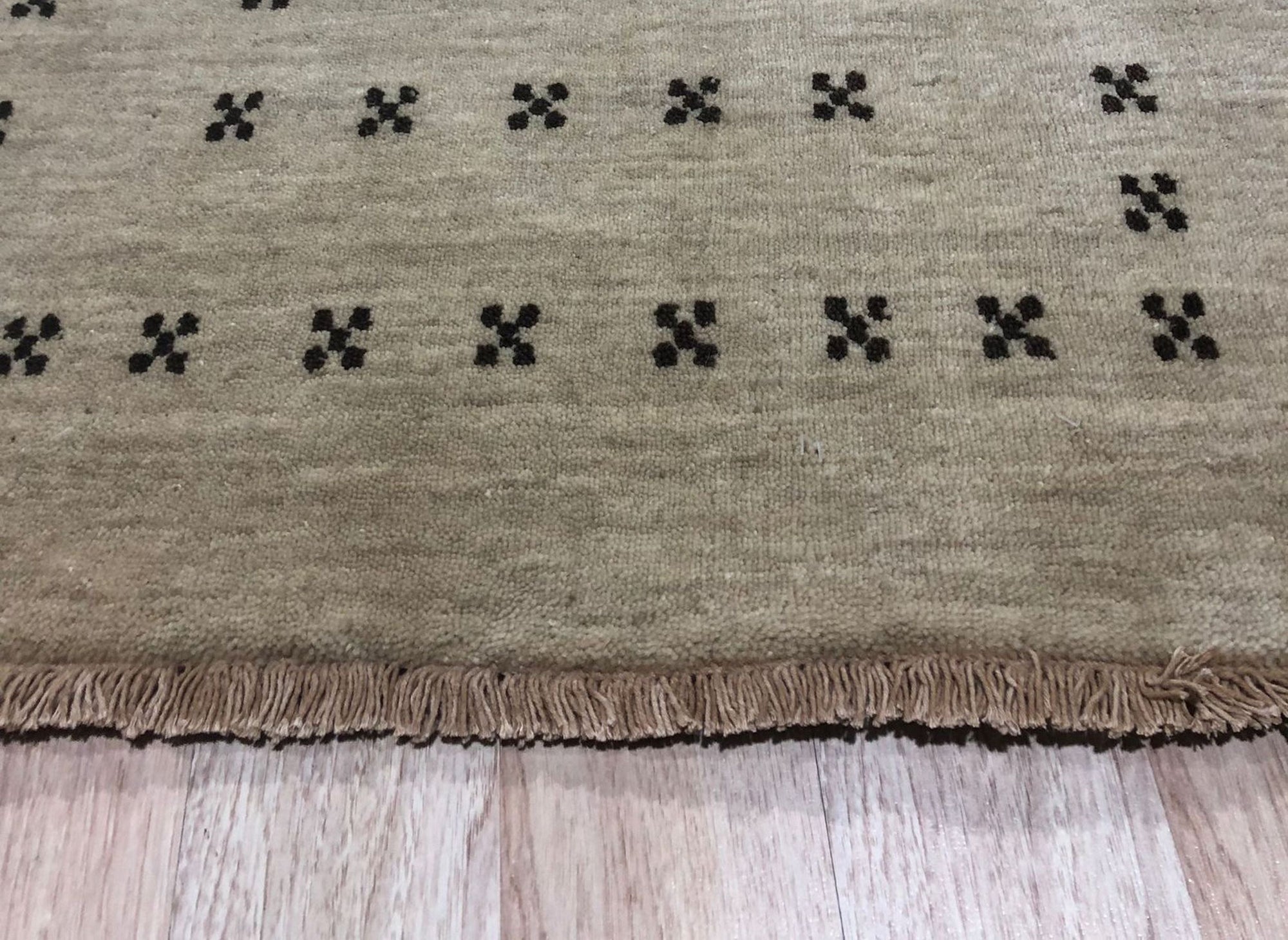 Jasmine Alluring Beige Handmade Wool Rug, its subtle beige tones and handcrafted wool texture lending warmth to a well-lit living room, positioned under a modern coffee table.