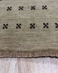 Jasmine Alluring Beige Handmade Wool Rug, its subtle beige tones and handcrafted wool texture lending warmth to a well-lit living room, positioned under a modern coffee table.