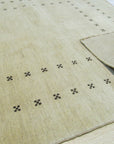 Jasmine Alluring Beige Handmade Wool Rug displayed, showcasing its soft, warm tones and handcrafted texture within a living room setting.