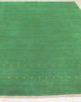 Jasmine Alluring Green Handmade Wool Rug, its verdant hues and handcrafted wool texture grounding a contemporary living space, sunlight dappling across its subtle, inviting pattern.