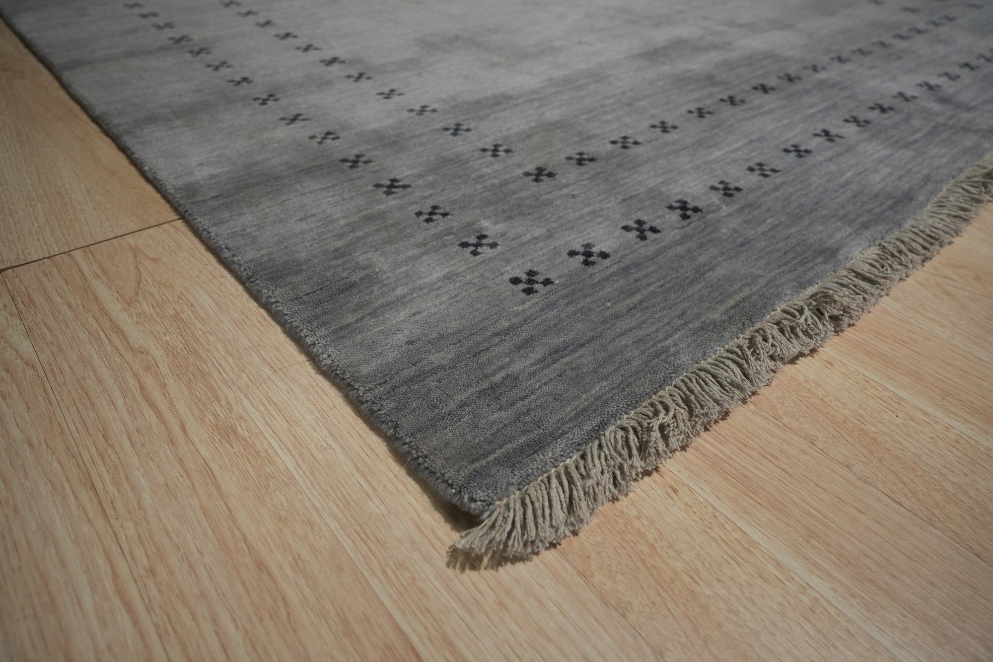 Jasmine Alluring Gray Handmade Wool Rug, seen in a bright living room setting; soft grays interplay with subtle textures in this wool rug, anchoring the space with understated elegance.