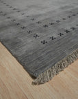 Jasmine Alluring Gray Handmade Wool Rug, seen in a bright living room setting; soft grays interplay with subtle textures in this wool rug, anchoring the space with understated elegance.