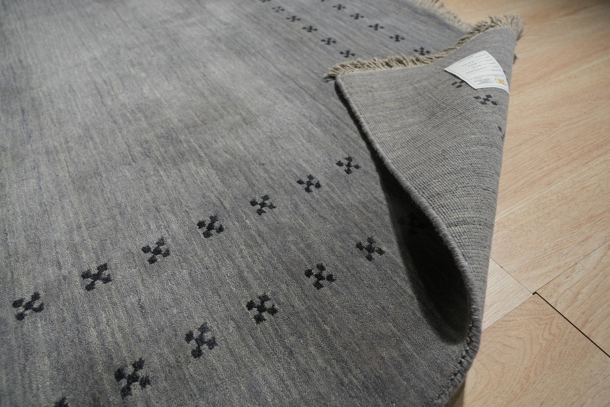 Jasmine Alluring Gray Handmade Wool Rug gracing a stylish living room; muted gray tones and subtle texture create an inviting, modern feel.