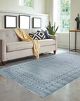 Jasmine Alluring Gray Handmade Wool Rug, invitingly textured and displaying subtle patterns, graces a warmly lit living space; handcrafted wool creates a soft, sophisticated gray floor covering.