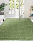 Jasmine Alluring Olive Handmade Wool Rug, its soft olive hues and textured wool pile lending warmth and sophistication to a bright living space.