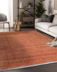 Jasmine Alluring Orange Handmade Wool Rug, vibrant threads bloom across a textured surface, its warm orange hues radiating outwards, casting a soft glow within the scene.