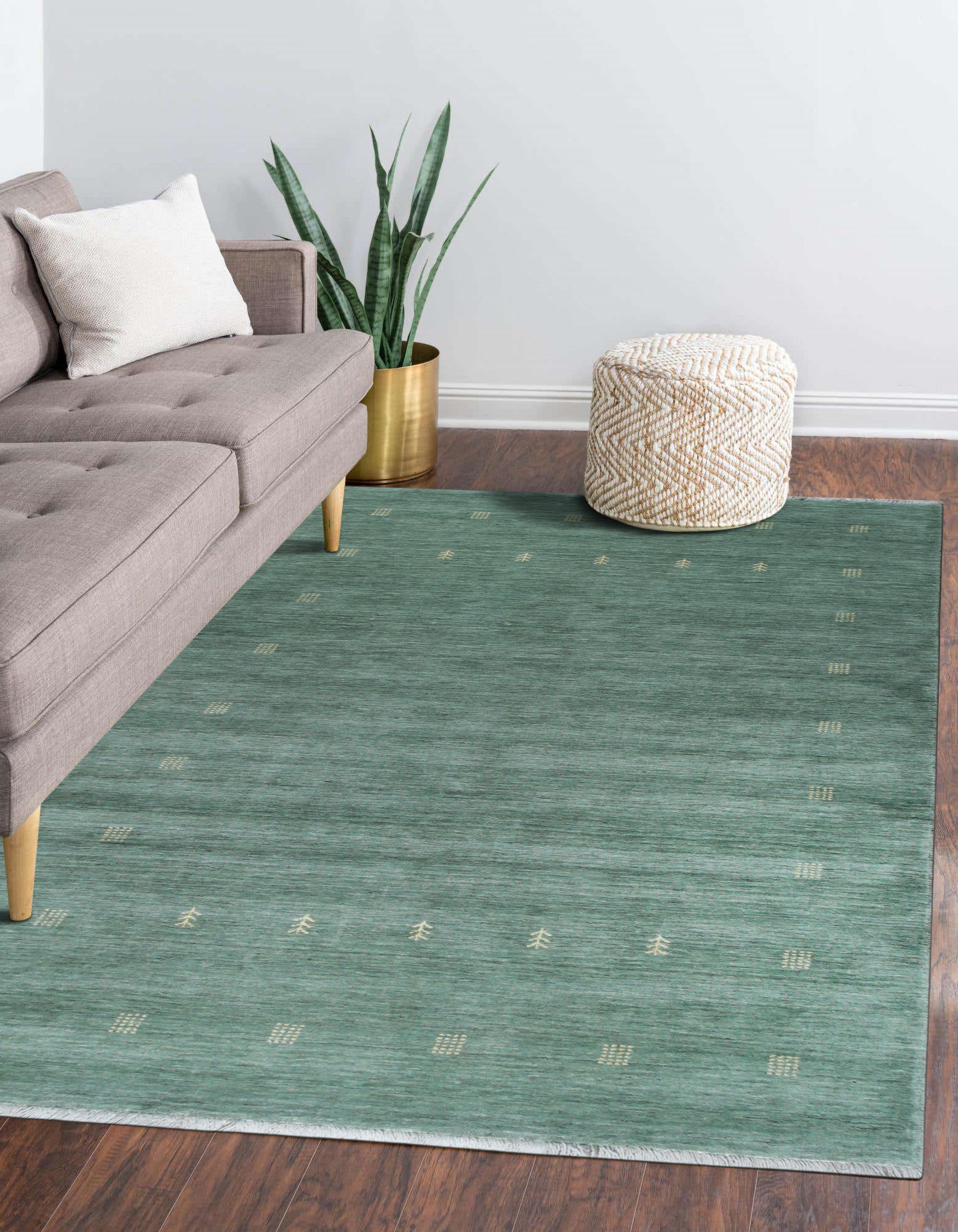 Laine Amara Green Handmade Wool Rug, displaying subtle textures and natural variations across its deep green wool surface, catches the light in a well-lit room setting.