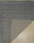 Sophie Alluring Gray Handmade Wool Rug displayed in a modern living space. Gray wool rug features a subtle, geometric pattern adding texture and warmth to the room with neutral-toned furniture.