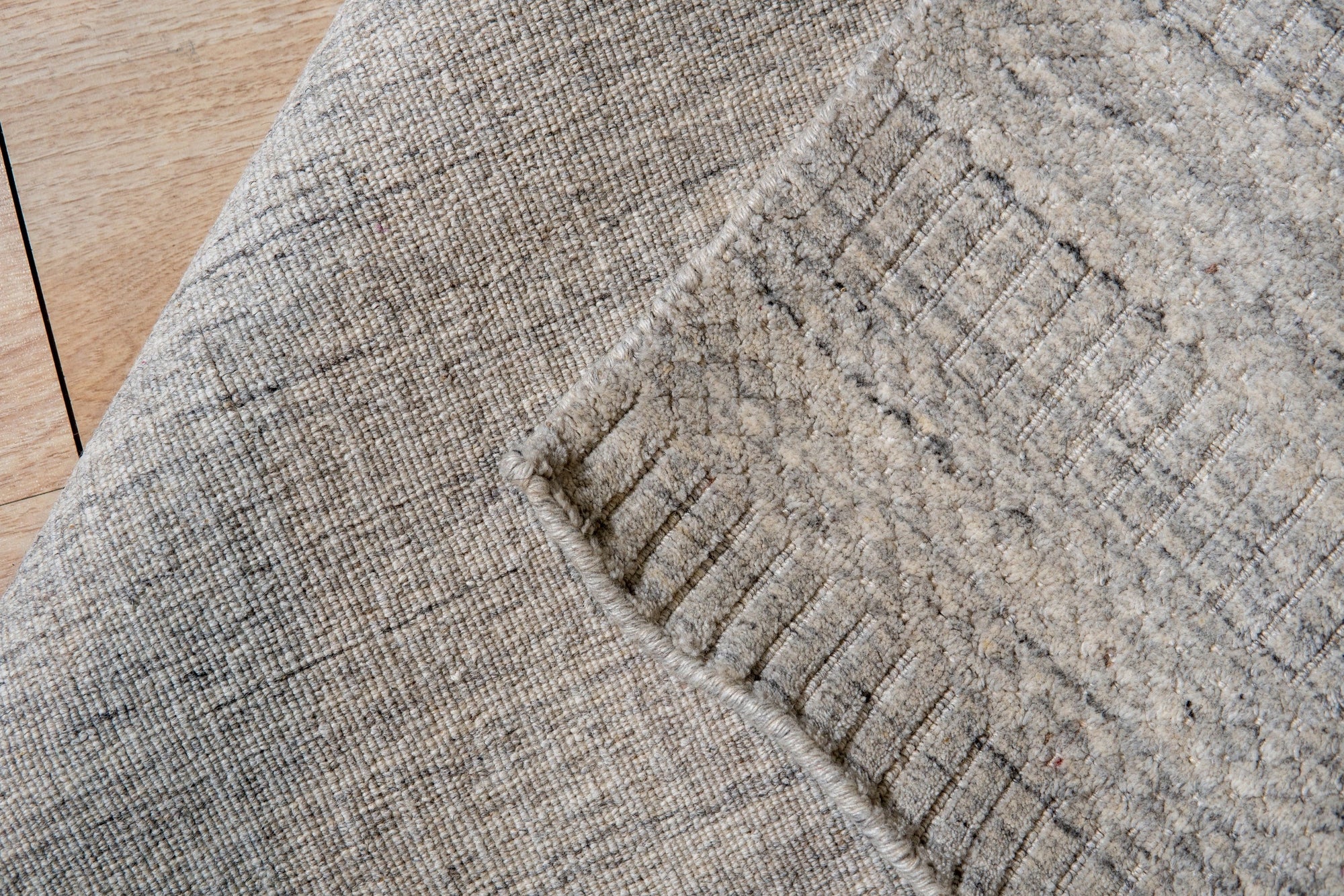 Celia Artistic Beige Handmade Wool Rug, showcasing its delicate beige tones and artistic pattern complementing a bright living room with modern furniture.