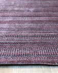 Radiant Elena Red Handmade Wool Rug, vibrant red hand-knotted wool rug with intricate floral and geometric patterns, partially visible within a brightly lit living room setting.