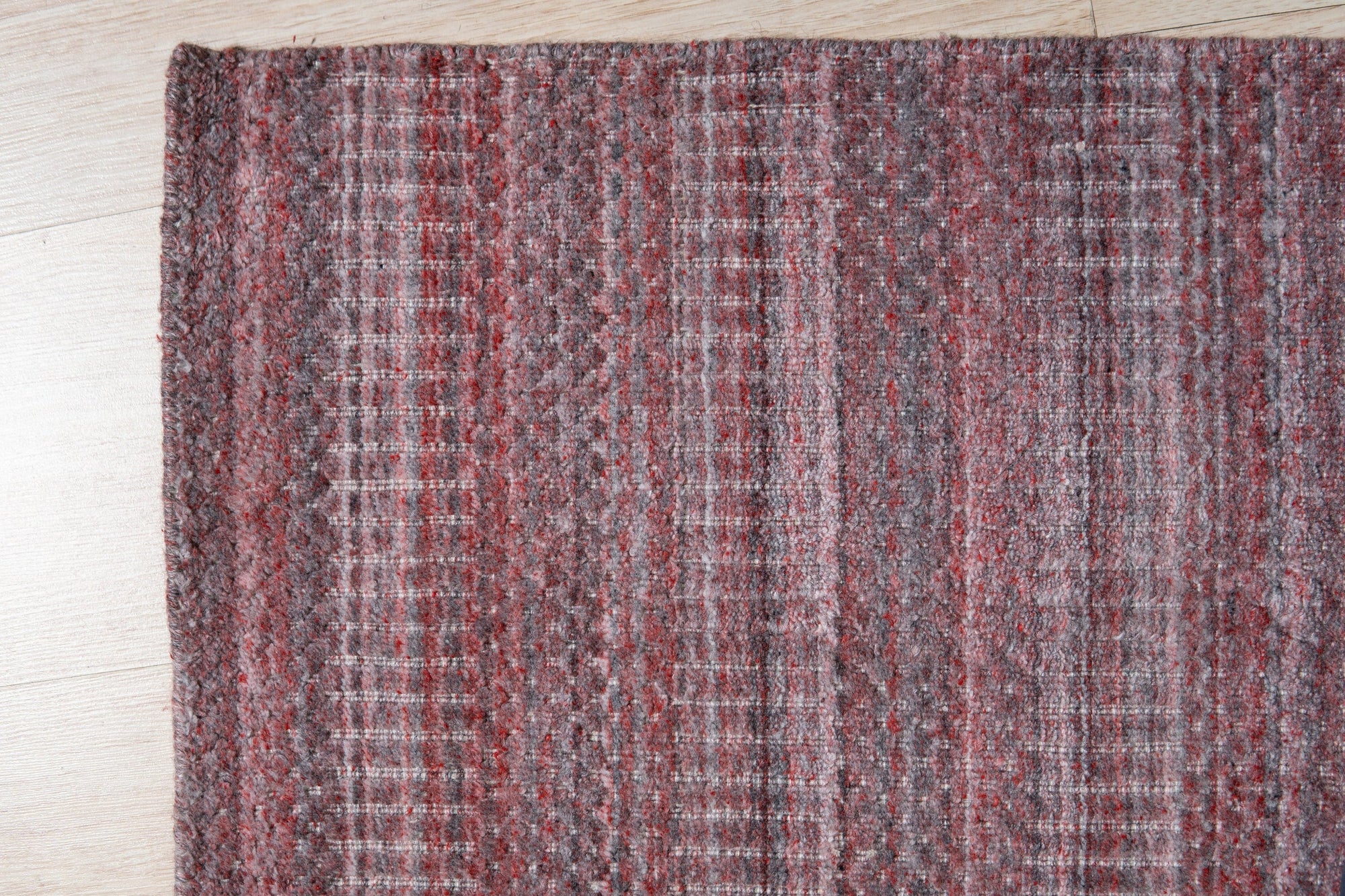 Radiant Elena Red Handmade Wool Rug, a rich crimson and warm ivory wool rug with an intricate, traditional design, lending elegance and vibrant color to a well-lit living room setting.