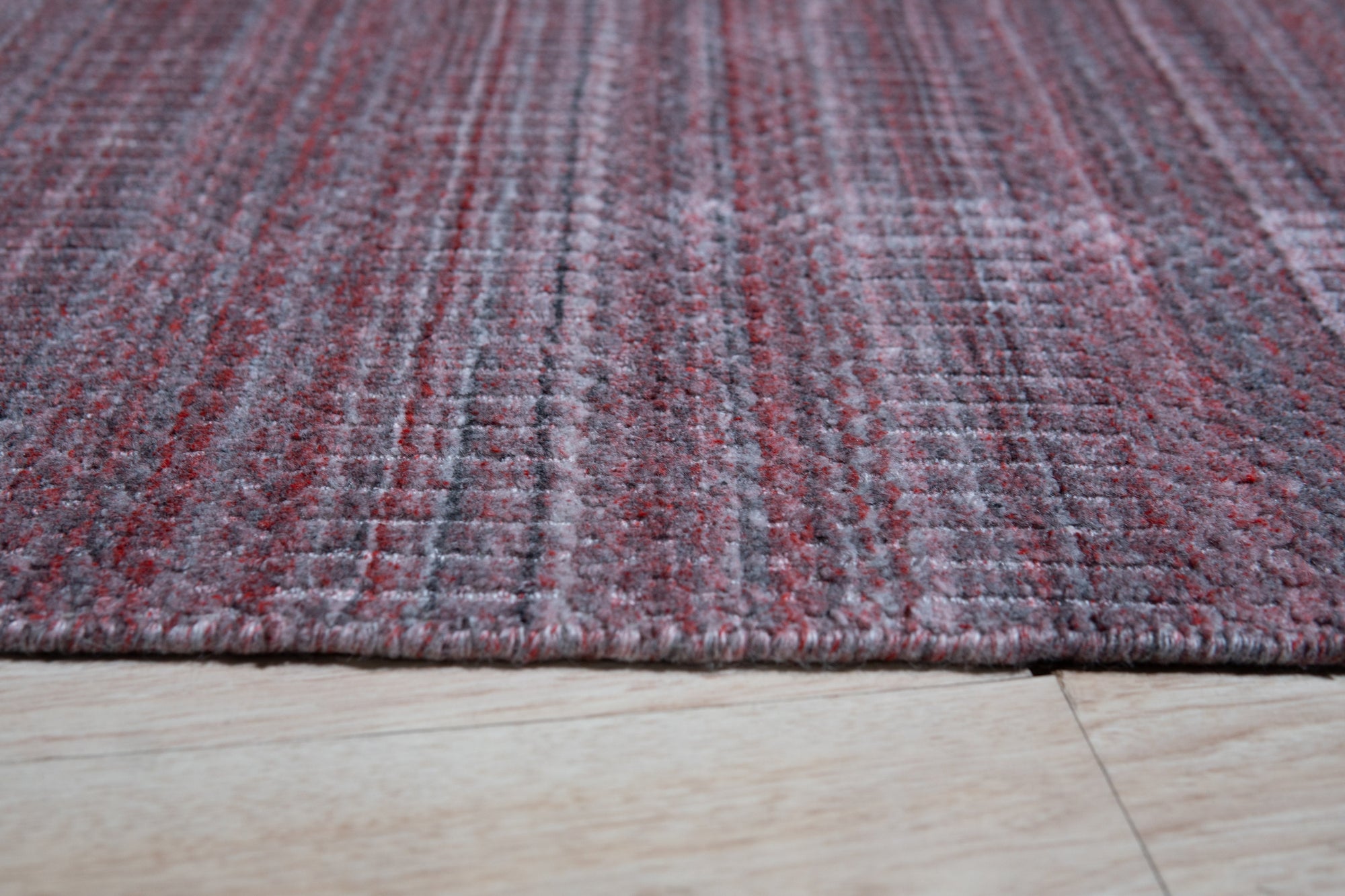 Radiant Elena Red Handmade Wool Rug, vibrant red wool rug with a classic, intricate design, elegantly displayed on a light wood floor, offering a warm and inviting feel.