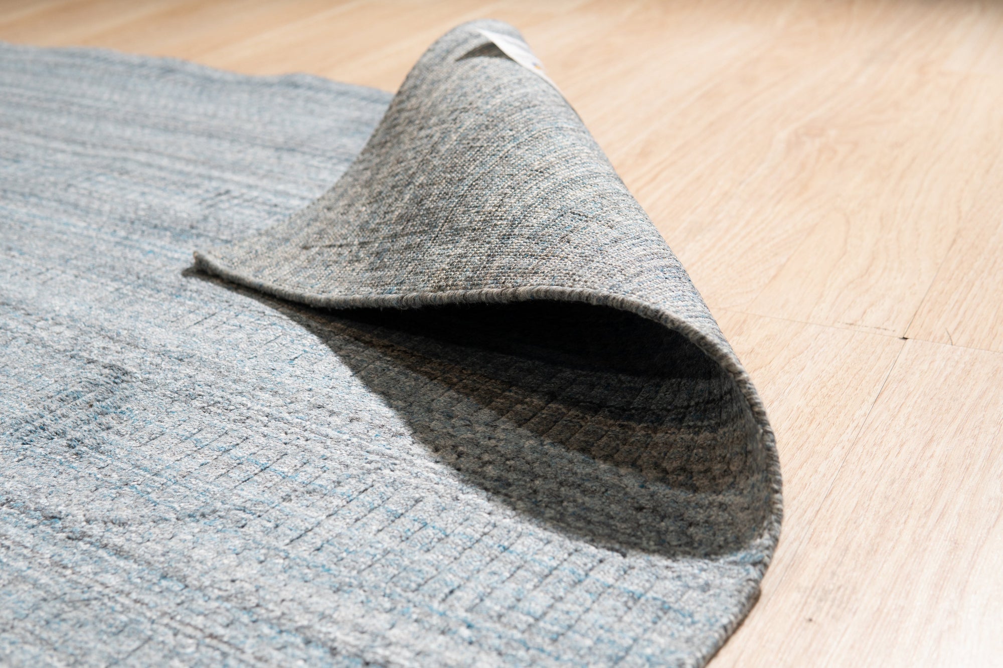 Para Elena Blue Handmade Wool Rug, showcasing a corner section with detailed hand-knotted texture and vibrant blue hues, revealing the rug's intricate design and luxurious wool construction.