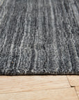 Penelope Nina Charcoal Handmade Wool Rug, featuring subtle patterns in varying shades of charcoal, creating depth and texture in a room setting.