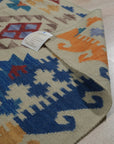 Nina Cassandra Multicolor Flatweave Wool Rug, vibrant hues dance across a flatweave wool texture, adding bohemian flair to a light-filled room with modern furniture.